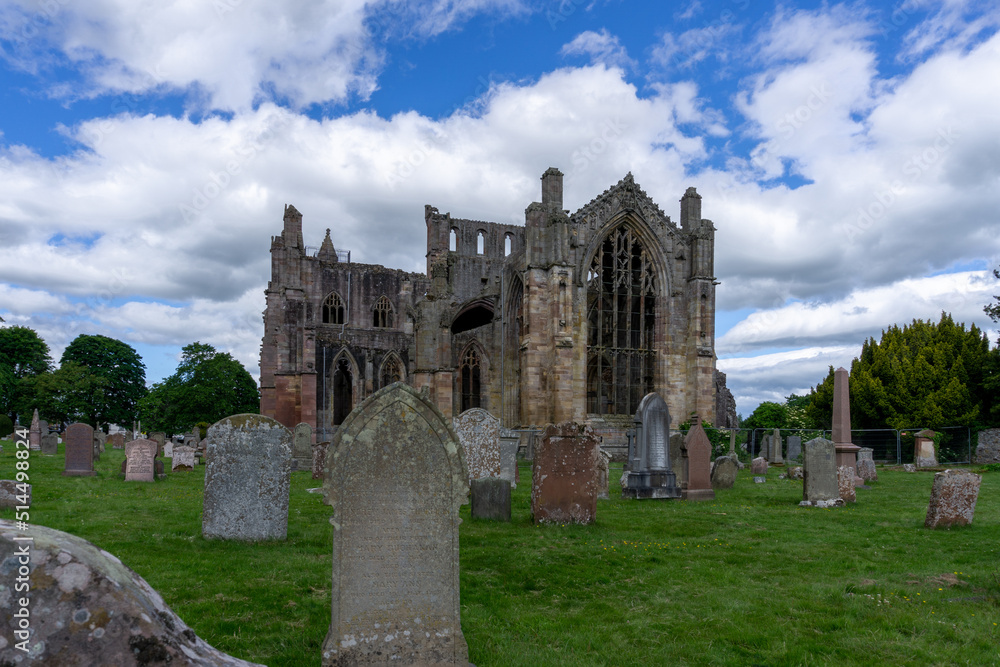view of the ruins of Melrose Abbey and historic headstones in the church cemetery