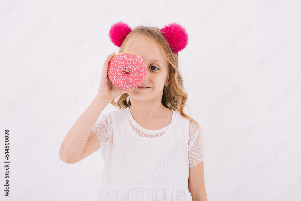 Funny little girl eating a donut on a white background Funny little girl eating a donut on a white background