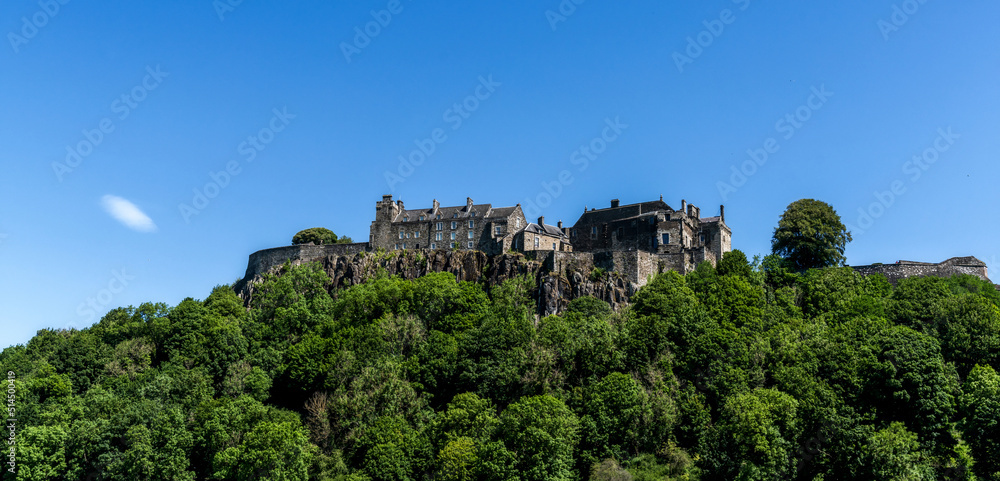 view of the Stirling Castle and Castle Hill with green summer forest under a blue sky