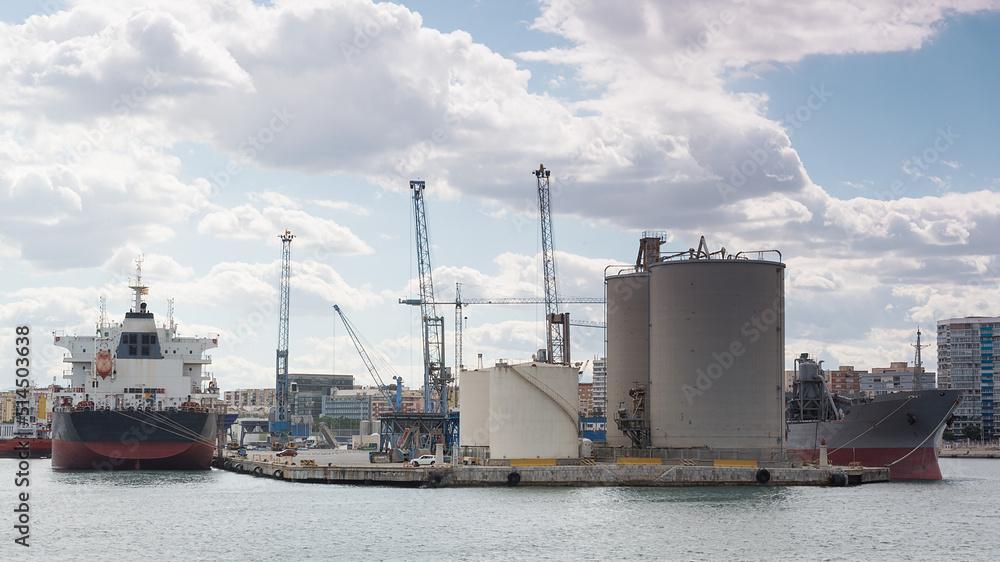 Hafen in Malaga mit Containerschiffen, Kränen und Silos Hafen in Malaga mit Containerschiffen, Kränen und Silos