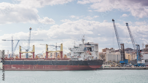 Hafen in Malaga mit Containerschiff das von Kränen beladen wird