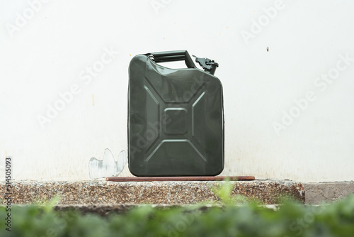 Green Jerrycan on white background. Gas canister full of gasoline. Fuel shortage while travelling far photo