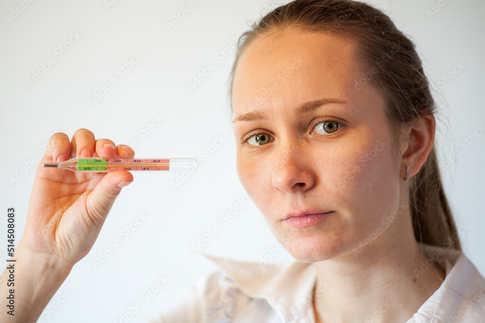 the girl measures the temperature during chills and coughs because she has a new coronavirus infection the girl measures the temperature during chills and coughs because she has a new coronavirus infection