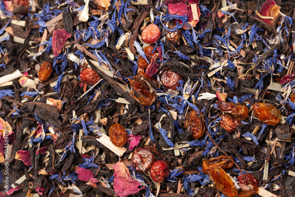 black tea with lemongrass, currant berries, sea buckthorn berries, rose petals, cornflower petals background top view black tea with lemongrass, currant berries, sea buckthorn berries, rose petals, cornflower petals background top view