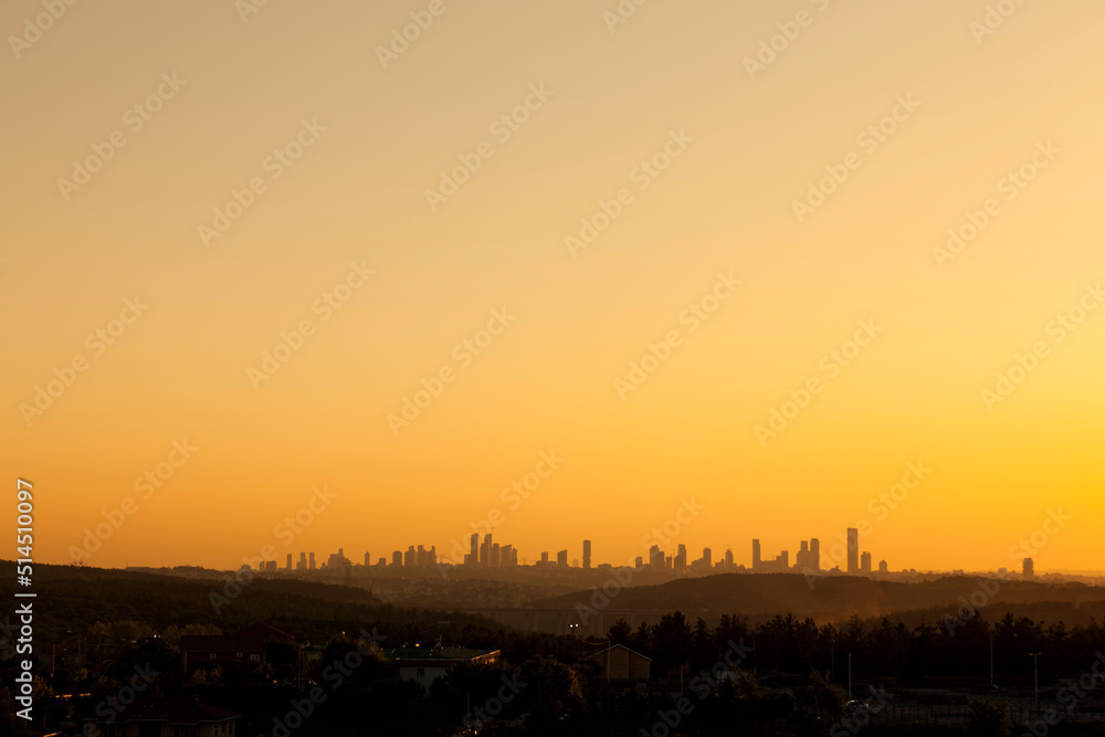 wide angle orange sunset scene with many skyscrapers and city center forest visible from real forest