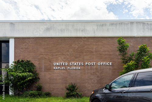 Naples city town in southwest Florida with Post Office sign on building brick architecture and car in parking lot photo
