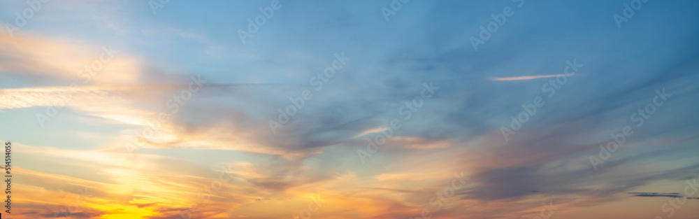 The sky at sunset or sunrise with orange clouds and a blue tint