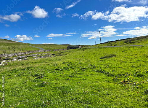 Landscape view  with the road to Settle  running past an old farm building near  Halton Gill  Skipton  UK