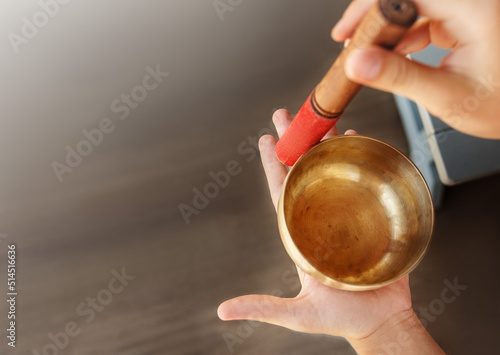 Man hands using singing bowl in sound healing therapy outdoors, closeup.