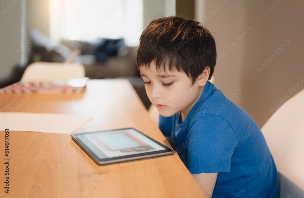 School kid studying online with teacher,Kid doing homework on tablet, Child boy using digital pad searching information on internet, Home schooling,E-learning online education,Children with technology School kid studying online with teacher,Kid doing homework on tablet, Child boy using digital pad searching information on internet, Home schooling,E-learning online education,Children with technology