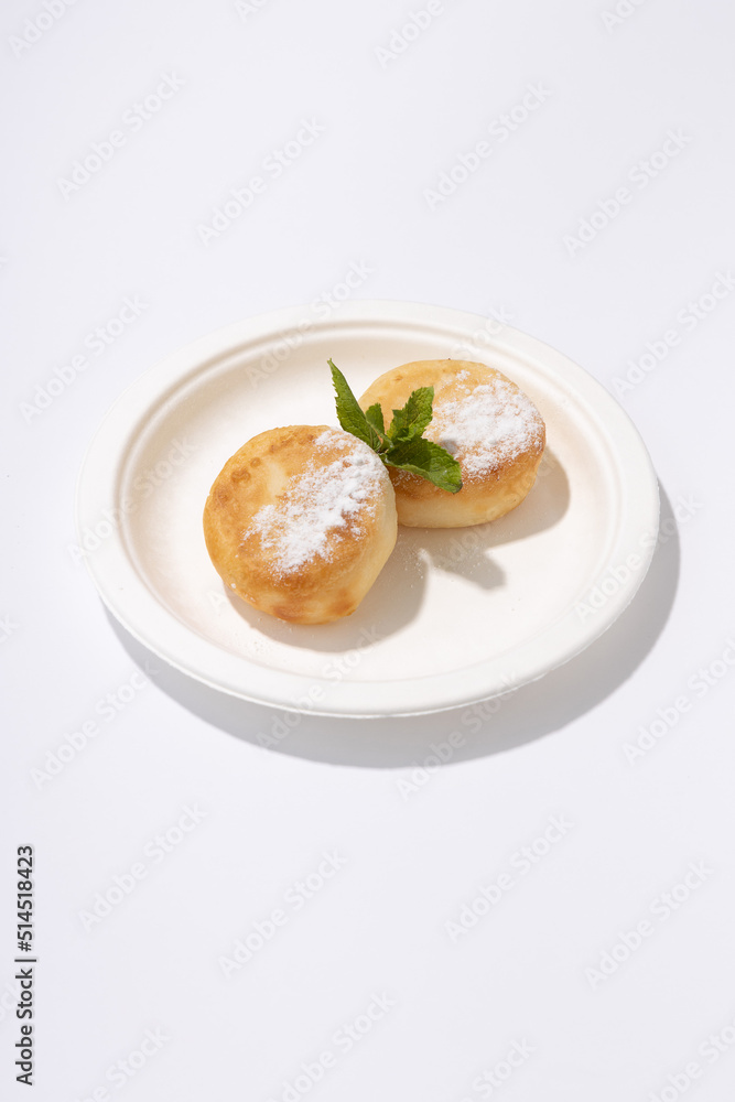 two cheesecakes on a plate on a white background two cheesecakes on a plate on a white background