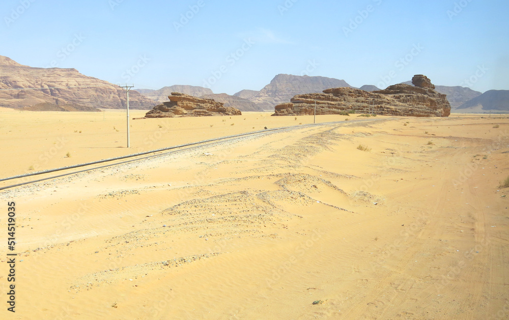 Fototapeta premium railroad tracks without train in the middle of the desert sand and some rocks