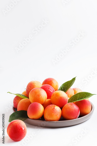 Apricots in a plate on a white background. Copy space