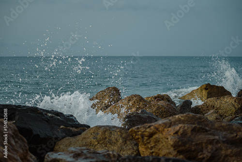 Sea waves lash line impact rock on the beach
