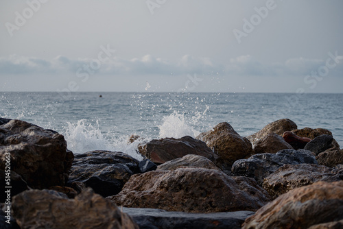 Sea waves lash line impact rock on the beach