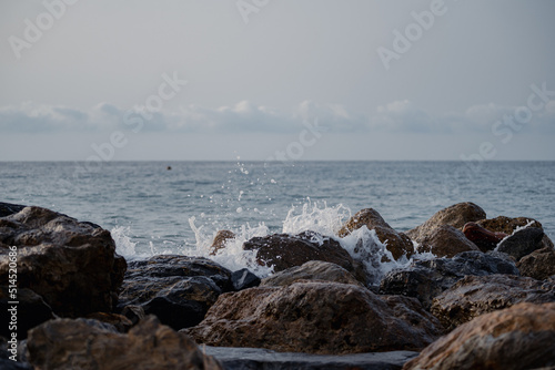 Sea waves lash line impact rock on the beach