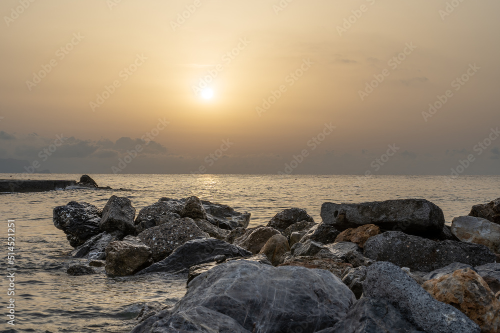 Sonnenuntergang am Meer in Italien. Vielfalt der Farben und Farben der aufgehenden Sonne. Meereslandschaft mit Wasser und Steinen. Sonnenuntergang am Meer in Italien. Vielfalt der Farben und Farben der aufgehenden Sonne. Meereslandschaft mit Wasser und Steinen.