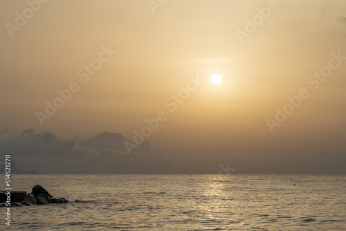 Sonnenuntergang am Meer in Italien. Vielfalt der Farben und Farben der aufgehenden Sonne. Meereslandschaft mit Wasser und Steinen.