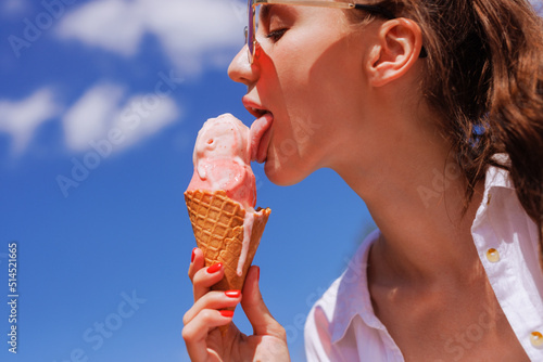 girl licks ice cream in a cone close-up in hot summer