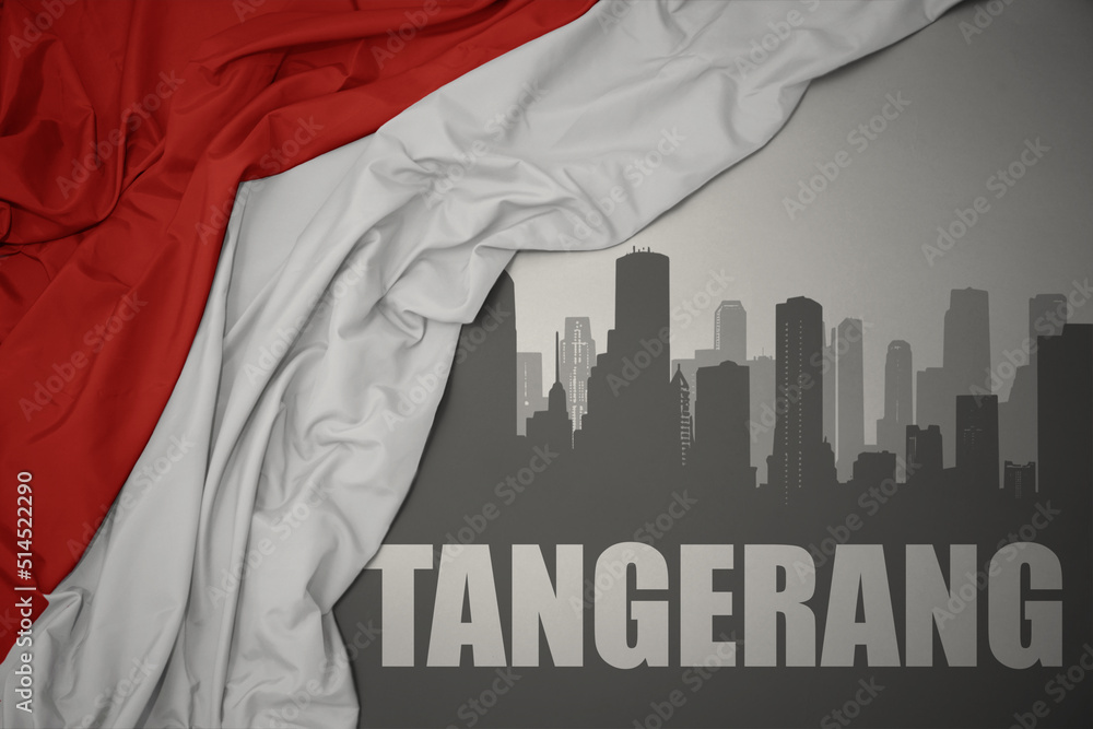 abstract silhouette of the city with text Tangerang near waving national flag of indonesia on a gray background.