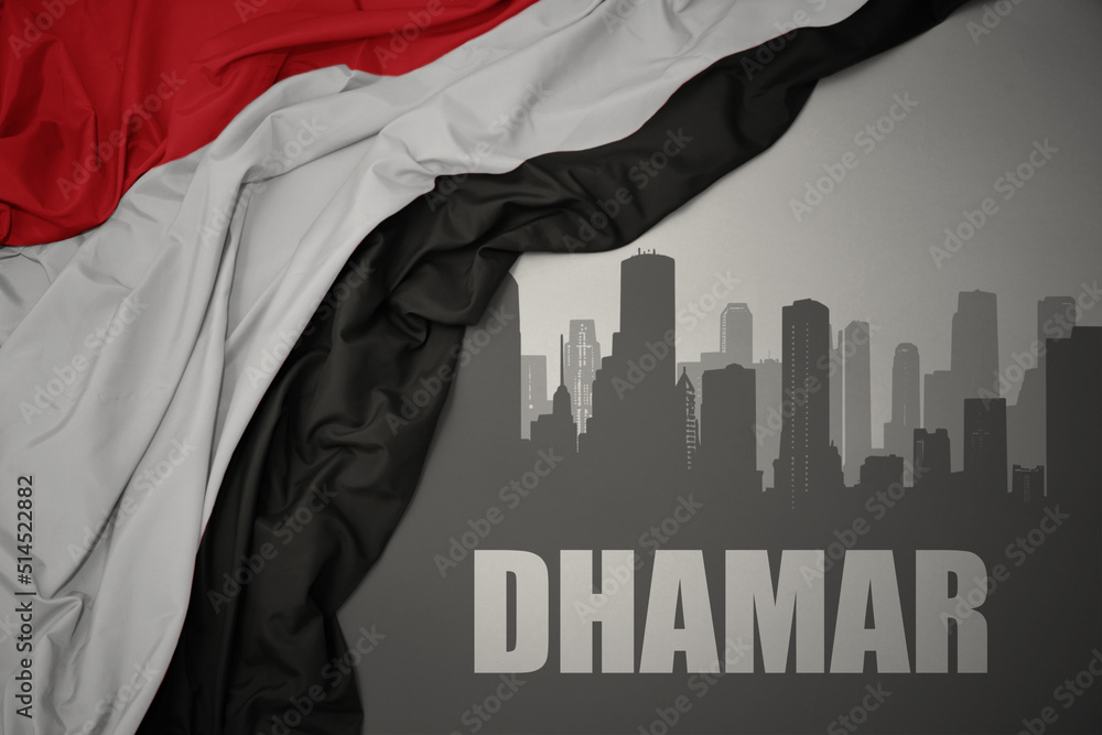 abstract silhouette of the city with text Dhamar near waving national flag of yemen on a gray background.