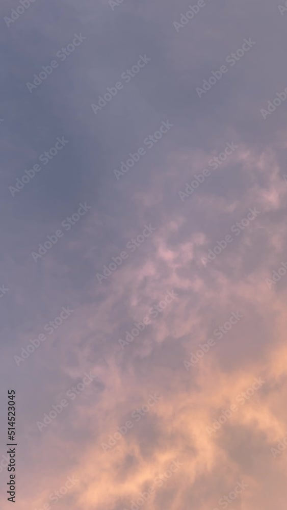 Early morning slow-moving cloudscape as viewed from below. Shades of blue, purple, peach and pink meld together to form a heavenly, serene background.