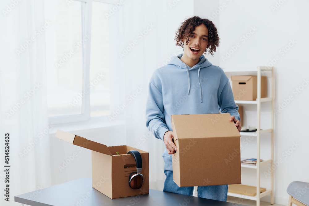handsome guy unpacking things from boxes in the room Lifestyle handsome guy unpacking things from boxes in the room Lifestyle