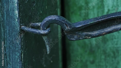 Man who is closing a wooden door in a house locked on a hook. 