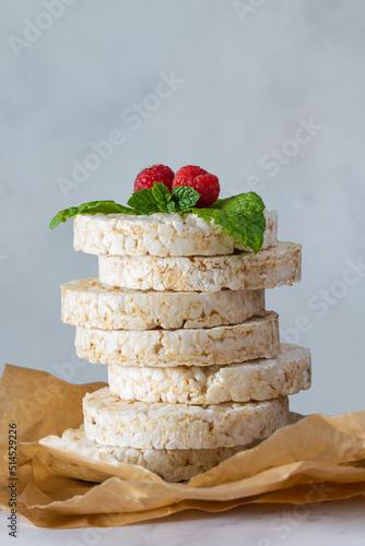 Rice wafers in a baking paper . Rice waffles with raspberries and mint leaves.