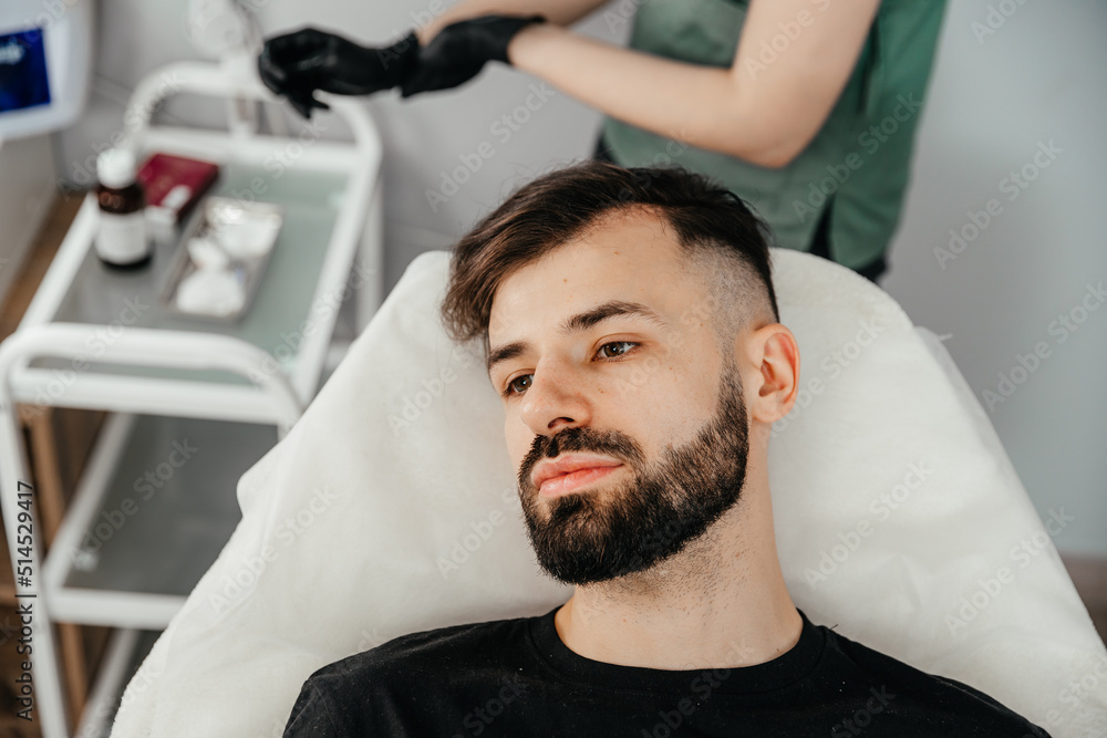 Mesotherapy. Injections with vitamins for hair growth on bald parts of the head in a young man Mesotherapy. Injections with vitamins for hair growth on bald parts of the head in a young man