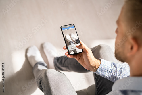 Man Trying Virtual Sneakers In Online Shop photo