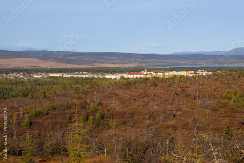View of the northern town and forest-tundra. Colored buildings in the distance. Nature and settlements of Siberia. Surroundings of the urban-type settlement of Ola. Magadan region  Far East of Russia.
