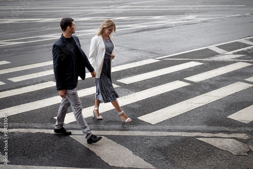couple in love walks together on a pedestrian crossing, a man and a woman walk in the city, the road