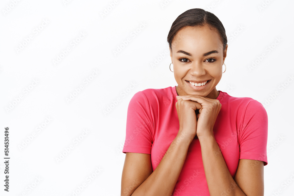 Close up of excited black woman, smiling and looking enthusiastic, waiting for smth, dreaming, standing over white studio background Close up of excited black woman, smiling and looking enthusiastic, waiting for smth, dreaming, standing over white studio background
