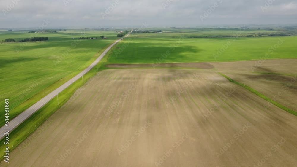 Aerial flight over prairie farm fields and a rural highway as moving cloud shadows travel across the landscape in Alberta Canada. Aerial flight over prairie farm fields and a rural highway as moving cloud shadows travel across the landscape in Alberta Canada.