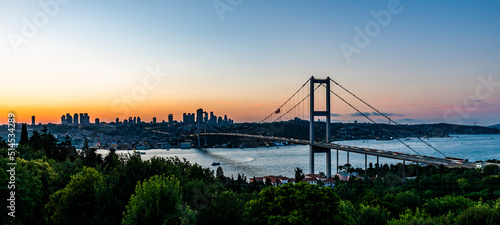 ISTANBUL, TURKEY. Panoramic view of Istanbul Bosphorus on sunset. Istanbul Bosphorus Bridge (15 July Martyrs Bridge. Turkish: 15 Temmuz Sehitler Koprusu). Beautiful cloudy blue sky.