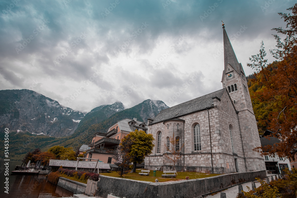 Church rising next to the old town of Hallstatt in Central Austria on a cloudy day in autumn. Picturesque village in Austria.