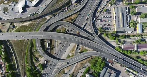 Circling view from drone moving up at the Kyiv transport interchange full of driving cars during the sunny day. photo