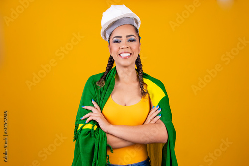 young brazilian woman engineer with brazilian clothes and flag.