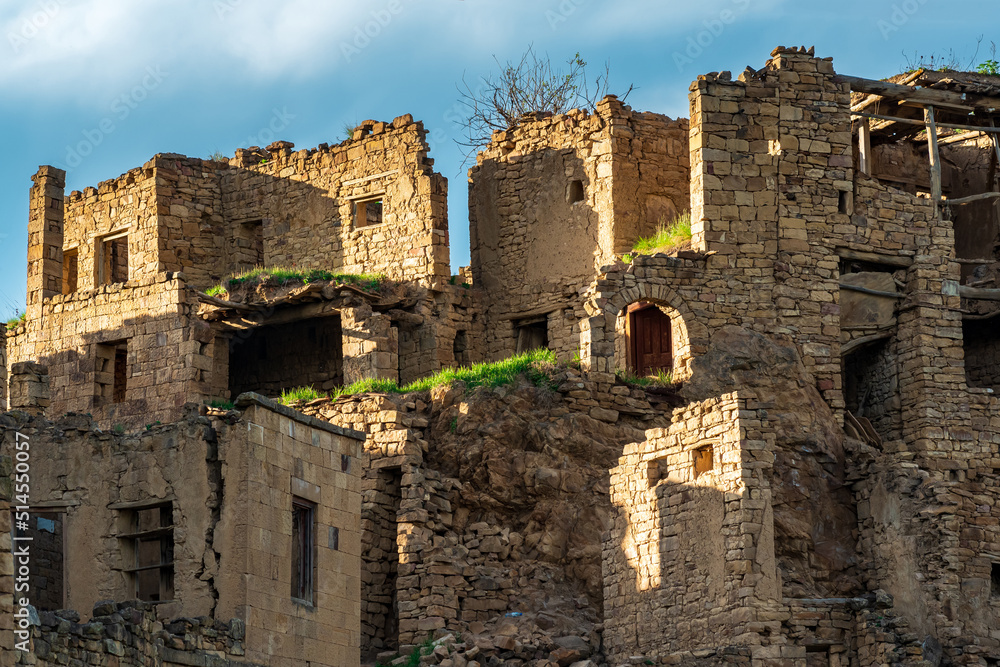 ruins of stone houses attached to the rock in the depopulated village of Gamsutl in Dagestan