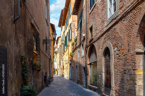 Fototapeta Naklejka Na Ścianę i Meble -  A typical street of shops and cafes inside the walled medieval city of Lucca, Italy, in the Tuscany region.