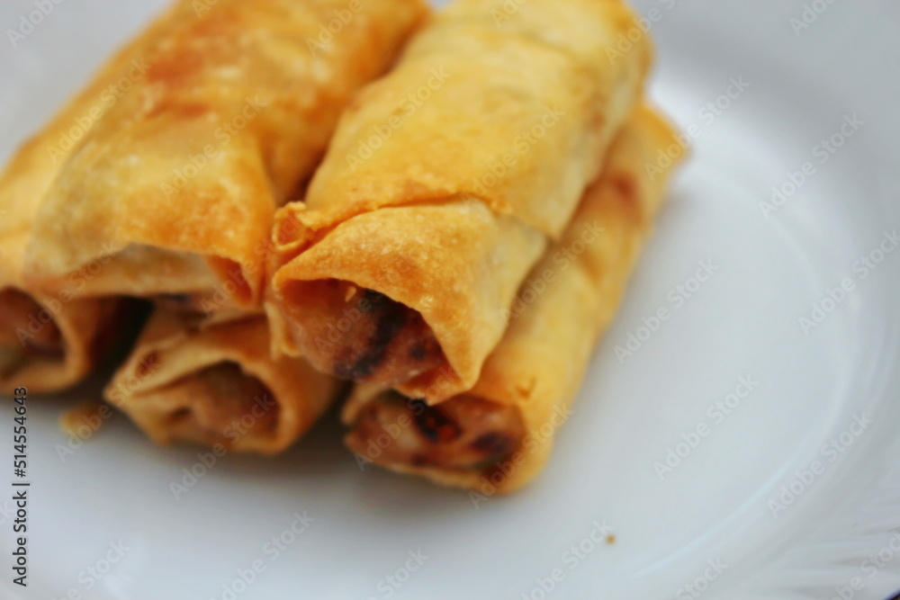 Fried spring rolls placed in a white plate, fried spring rolls are a popular Asian dish.