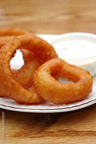 Fried onions served in small white plates in American restaurants.