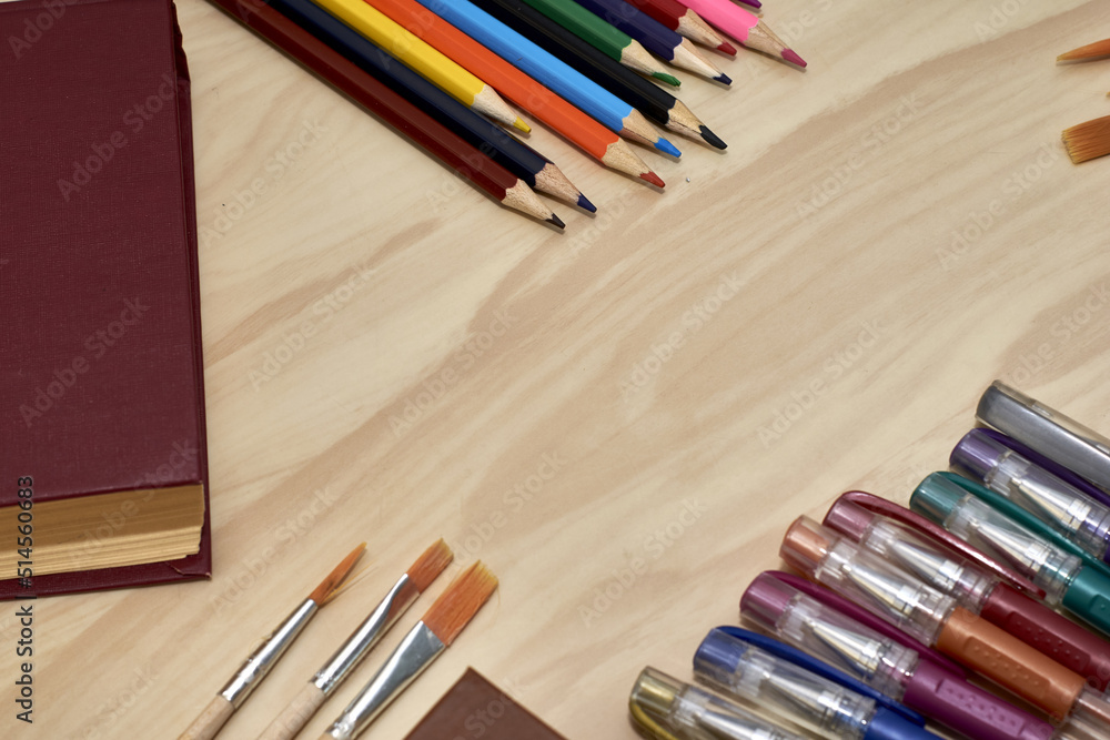 Fototapeta premium books pencils fountain pens and brushes for drawing on the table concept education school