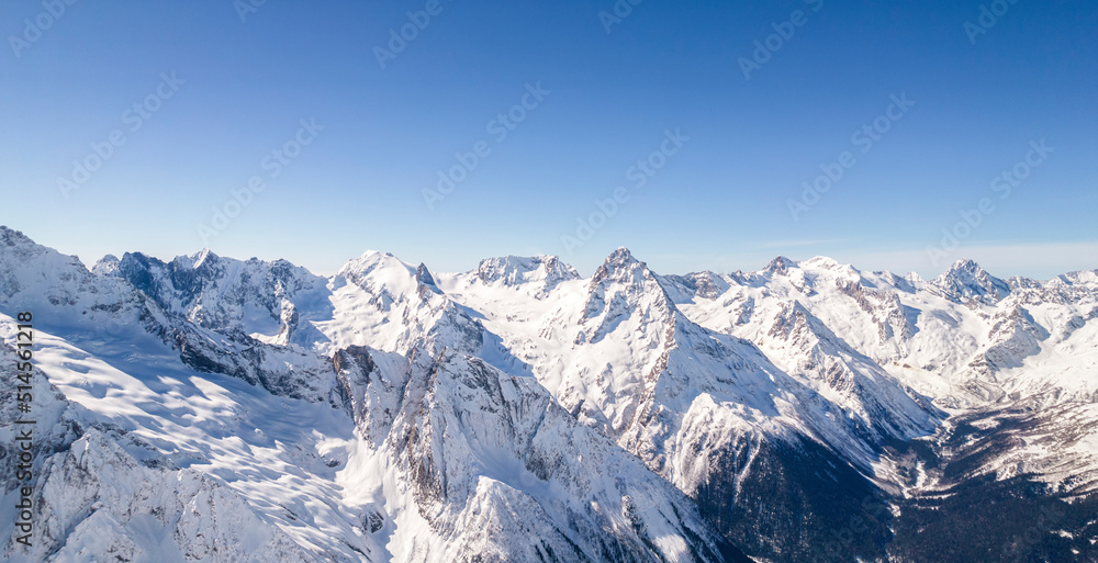 Mountain range covered with snow against a blue sky 