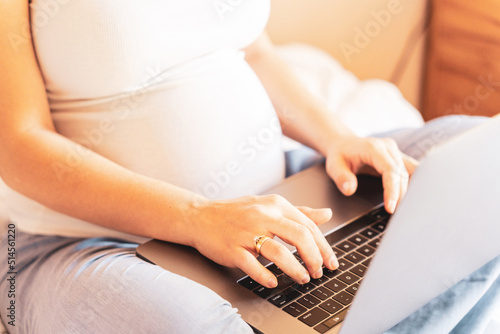 Pregnant computer. Pregnant woman holding digital laptop. Mobile pregnancy online maternity application. Concept of pregnancy  maternity  expectation for baby birth.