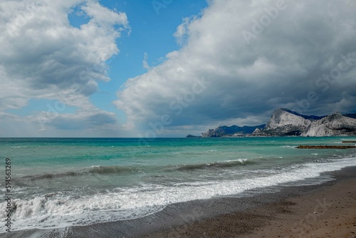 emerald sea against the background of mountains and sky with dark clouds