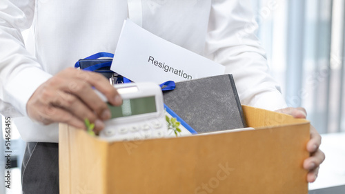 Female employee submits her resignation letter and packs her work equipment in a box to prepare to move to work, Can't bear the burden or pressure, Employment contract is expired. © Puwasit Inyavileart