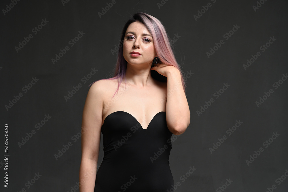 Naklejka premium Studio shot of a beautiful woman posing in a bodysuit against a dark background.