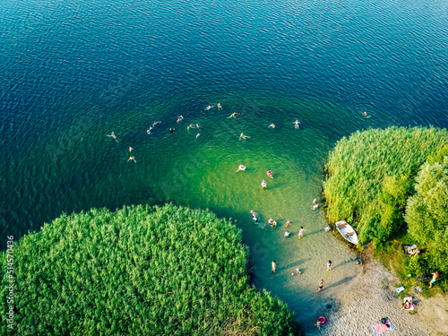 Fototapeta Naklejka Na Ścianę i Meble -  Summer time at the lake. Rest on the beach. Aerial view of small hidden beach.